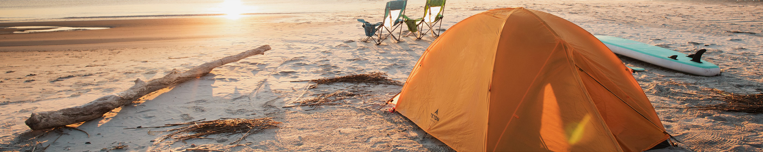 A lone TETON Sports Mountain Ultra Tent is set-up on a deserted beach at sunrise.