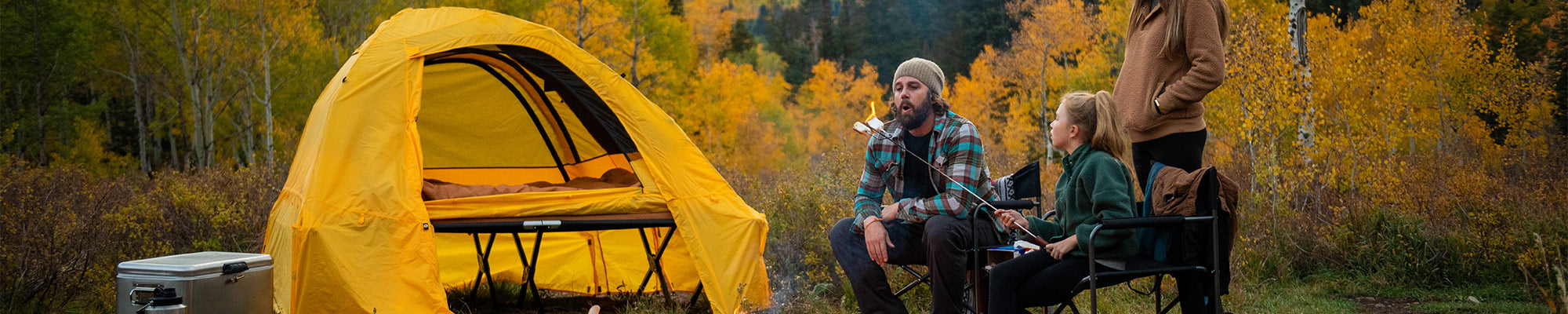 A family camps together in an autumn forest using TETON Sports tents & camping gear.