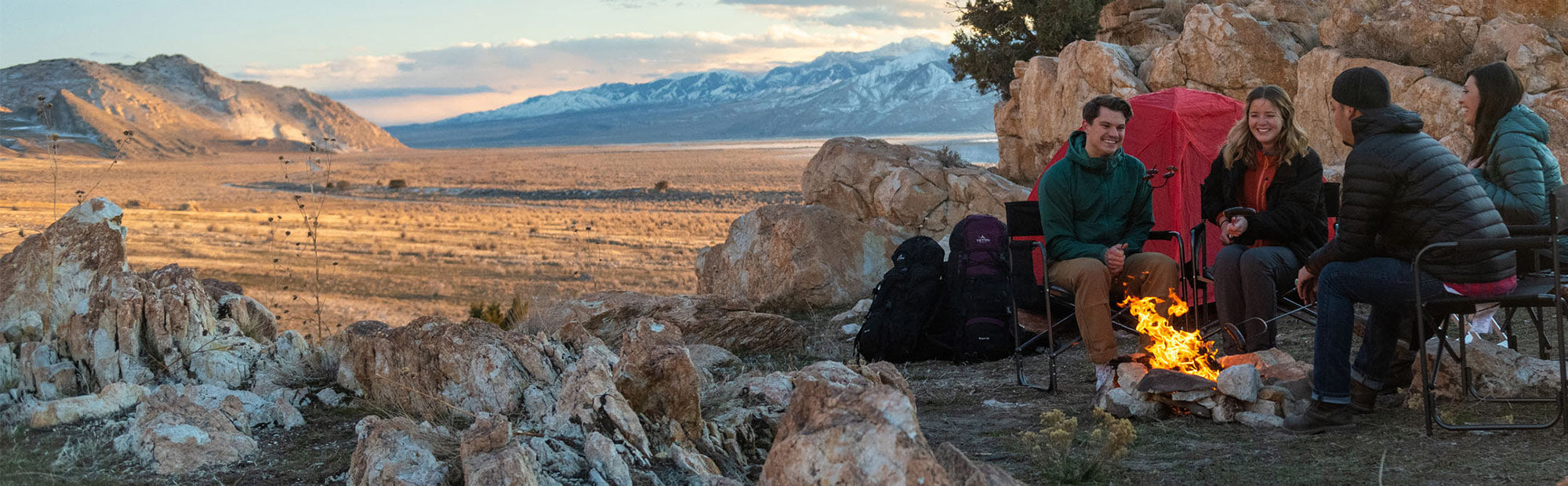 TETON's Lifetime Warranty: Image shows a group of friends sitting around a campfire surrounded by TETON Sports Mountain Ultra tents.